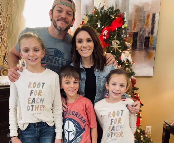 Matt Carriker smiling with his wife Kelly Carriker and children outdoors in Texas