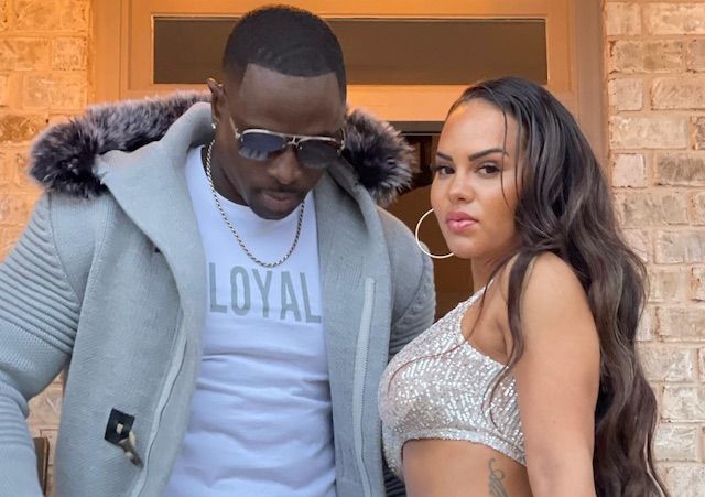 Rod Gardner and his wife Leticia flexing in orange fitness outfits outdoors